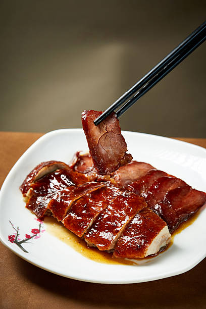 duck slices are placed on a plate and picked up with chopsticks